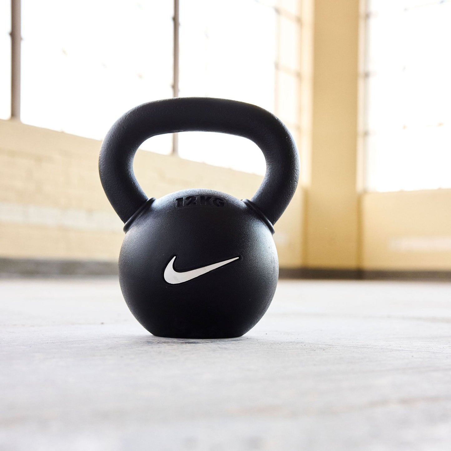 Black rubber-coated kettlebells in use during functional training session showing proper form and versatility.