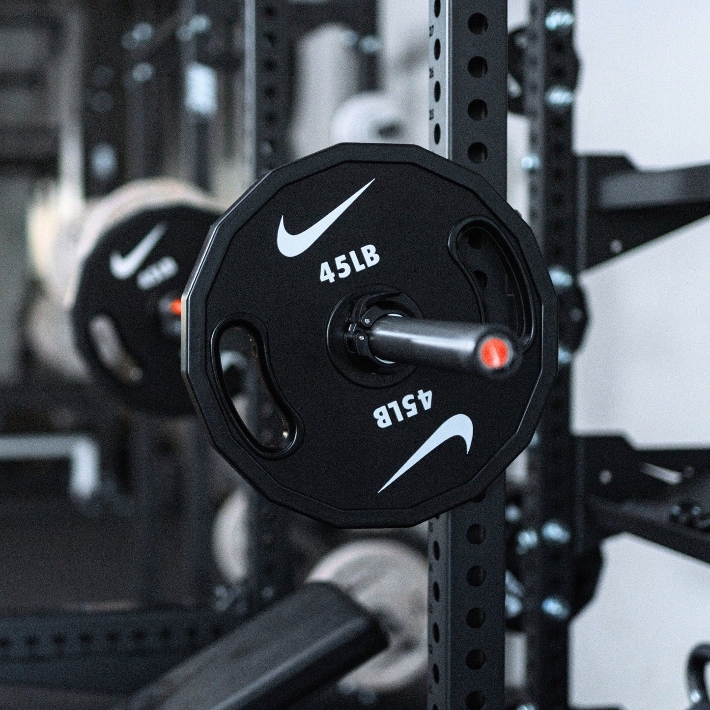 Nike Strength weight plate close-up showing premium construction, grip design, and weight marking details.