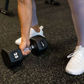 Black hex dumbbells arranged in increasing weight order on professional rack for organized strength training.