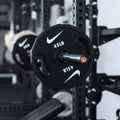Nike Strength weight plate close-up showing premium construction, grip design, and weight marking details.